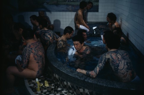 Heavily tattooed gangster or Yakuza gang members in public bath house
