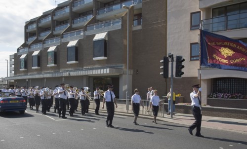 ENGLAND, West Sussex, Worthing, The Salvation Army Band marching along seafront with flags flying