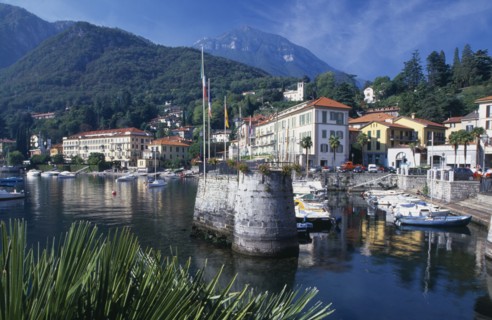 ITALY, Lombardy, Lake Como, Menaggio.  Harbour with moored boats and waterside buildings with tree