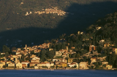 ITALY, Lombardy, Lake Como, Torno.  View across Lake Como towards town spread across hillside in