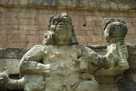 HONDURAS, Copan, Site of ancient Mayan ruins.  Detail of statue of figure holding burning torch.