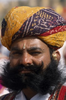 INDIA, Rajasthan, Jaisalmer, Head and shoulders portrait of a Mr Desert contestant with a beard