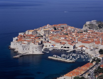 CROATIA, Dalmatia, Dubrovnik, Elevated view over the Old City Harbour with fortified walls. Yachts