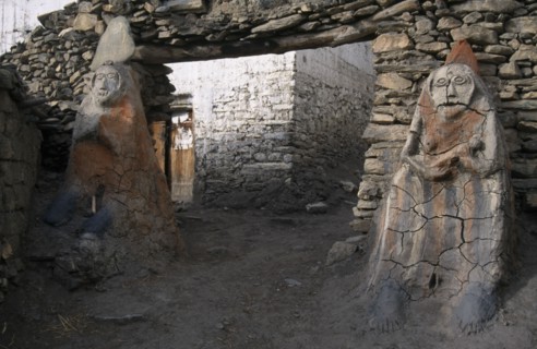 NEPAL, Annapurna Circuit Trek, Male and female Animistic protector guardians by the entrance