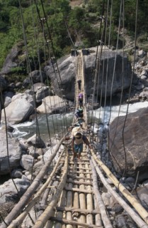 NEPAL, Annapurna Circuit Trek, Crossing a sagging suspension bridge over the Khudi Khola at Khudi.
