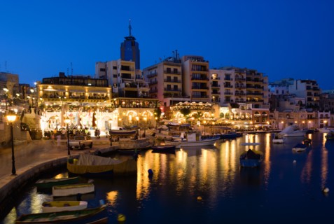 MALTA, Saint Julians, Saint Julians Bay waterfront at dusk with illuminated restaurants in front of