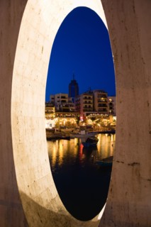 MALTA, Saint Julians, Saint Julians Bay waterfront at dusk with illuminated restaurants in front of