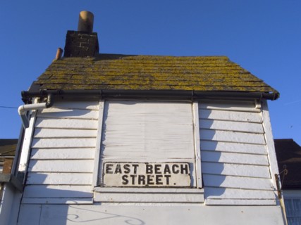 ENGLAND, East Sussex, Hastings, East Beach Street sign on white wooden building