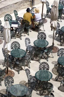 MALTA, Valletta, Couple of people sitting at a table amongst other wrought iron tables and chairs