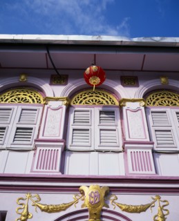 MALAYSIA, Penang, Georgetown, Pink and gold painted shopfront with wooden window shutters and red