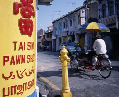 MALAYSIA, Penang, Georgetown, Lebuh Chulia.  Cycle rickshaw on street with yellow and red painted