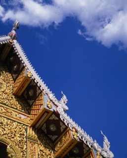THAILAND, North, Chiang Mai, Detail of highly decorated temple roof with painted carvings of naga