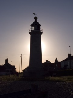 ENGLAND, West Sussex, Shoreham-by-Sea, Lighthouse silhouetted at sunset