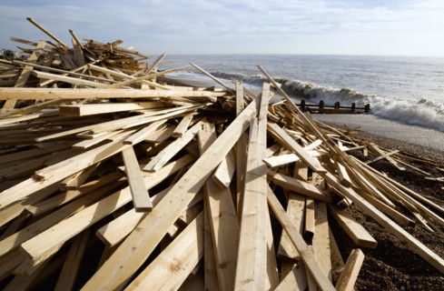 ENGLAND, West Sussex, Worthing, Timber wood planks washed up on the beach seafront from the