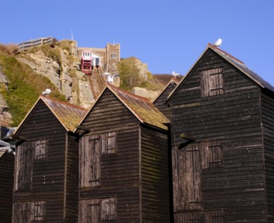 ENGLAND, East Sussex, Hastings, Black wooden huts used for storing fishing nets.The East Hill Lift