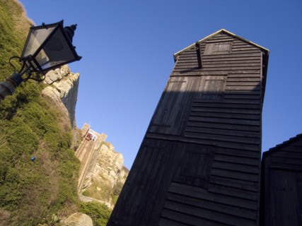 ENGLAND, East Sussex, Hastings, Black wooden huts used for storing fishing nets.The East Hill Lift