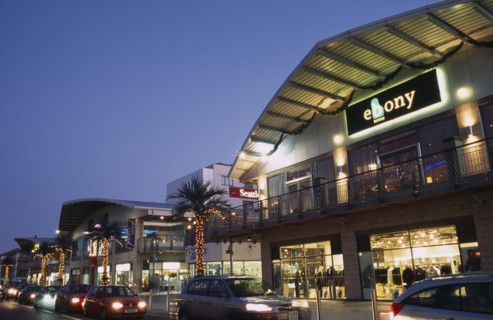 ENGLAND, East Sussex, Brighton, Brighton Marina shops and bars illuminated in evening light