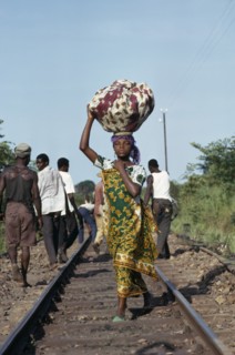 CONGO, Shaba Province, People, Young woman dressed in traditional local textiles carrying bundle on