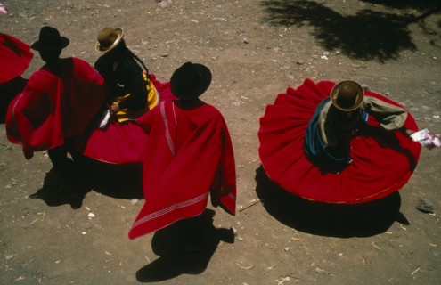 20088972 PERU Puno Lake Titicaca Aymara Andean Indian dancers wearing red skirts and ponchos during marriage festivities