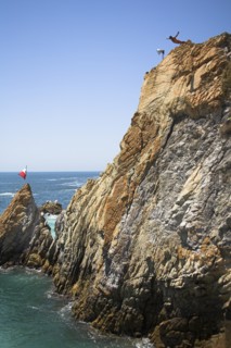 MEXICO, Guerrero State, Acapulco, "Cliff diver, a clavadista, diving off the cliffs at La Quebrada"