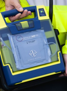 ENGLAND, West Sussex, Findon, Sheep Fair Ambulance service driver holding a mobile emergency
