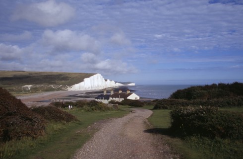 ENGLAND, East Sussex, Seven Sisters, The Seven Sisters white chalk cliffs viewed from a path at
