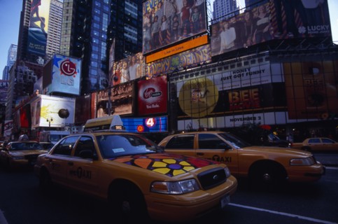 USA, New York, New York City, Times Square.  Yellow taxi cabs on street lined with skyscraper