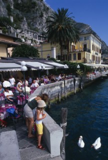 ITALY, Lombardy, Lake Garda , Limone Sur Garda.  Busy lakeside cafe with people sitting at tables
