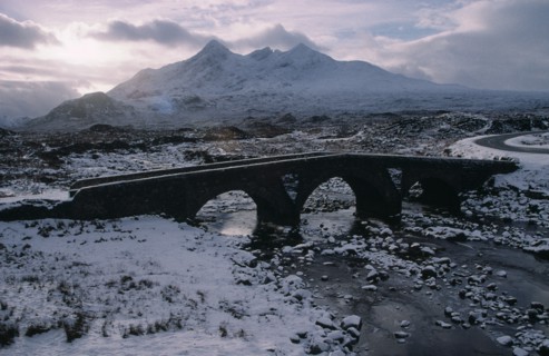 SCOTLAND, Isle of Skye, Sligachan and the Cuillin Mountains in winter snow.  Narrow bridge over