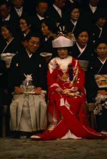 JAPAN, Honshu, Tokyo, Seated bride and groom and guests attending Shinto wedding ceremony wearing