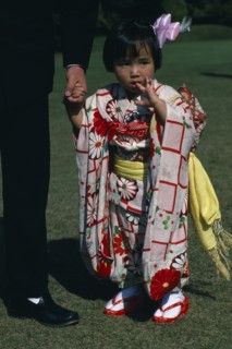 JAPAN, Honshu, Tokyo, Little girl holding the hand of a part seen guest at Shinto wedding ceremony