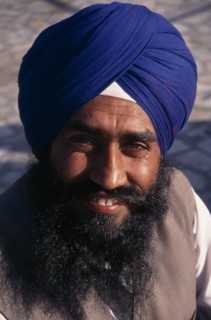 INDIA, Delhi, Head and shoulders portrait of Sikh man wearing blue turban.