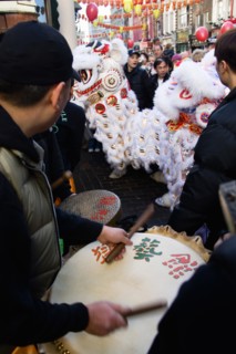 ENGLAND, London, Chinatown, Lion Dance troupe and musicians performing in Wardour Street amongst