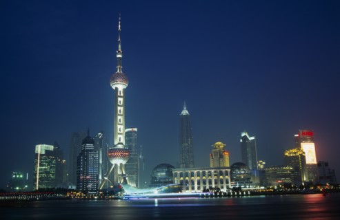 CHINA, Shanghai, Pudong at night with illuminated skyscrapers and buildings including the Oriental