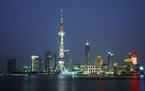CHINA, Shanghai, Pudong at night with illuminated skyscrapers and buildings including the Oriental
