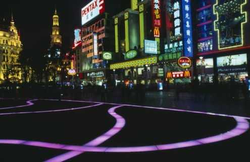 CHINA, Shanghai, "Nanjing Lu.  Street scene at night with illuminated coloured pavement trail, neon