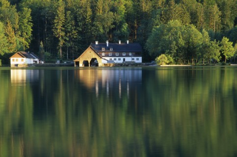 AUSTRIA, Oberosterreich, Mondsee, View across lake towards boat house and other building with