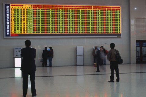 CHINA, Beijing, Interior of railway terminal with electronic information board with customers
