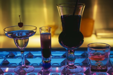 CHINA, Beijing, Tou Ming Si Kao (TMSK) bar.  Cocktails on glass bar illuminated blue and purple.
