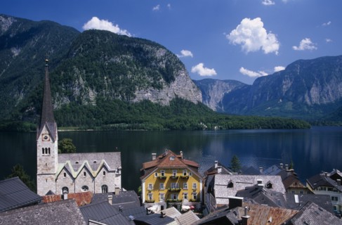 AUSTRIA, Oberosterreich, Hallstatt, "View over tiled village rooftops, hotel and church with lake