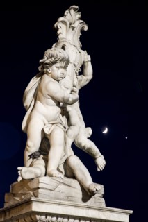 ITALY, Tuscany, Pisa, An illuminated statue in The Piazza del Duomo of cherubs holding a shield