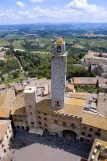 ITALY, Tuscany, San Gimignano, People in the Piazza del Duomo with the town's oldest tower of the