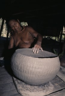 COLOMBIA, Choco, Embera Indigenous People, Embera woman puts final touches to a large clay cooking