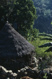 COLOMBIA, Sierra Nevada de Santa Marta, Ika, Ika man woman and child outside circular mud-wattle
