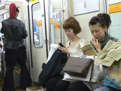JAPAN, Honshu, Tokyo, "Ginza - three women on a subway train, right side young woman, shopping bags