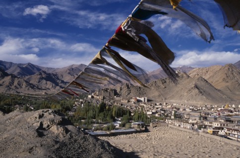 INDIA, Ladakh, Leh, Prayer flags on hillside above Leh spread out across valley below.