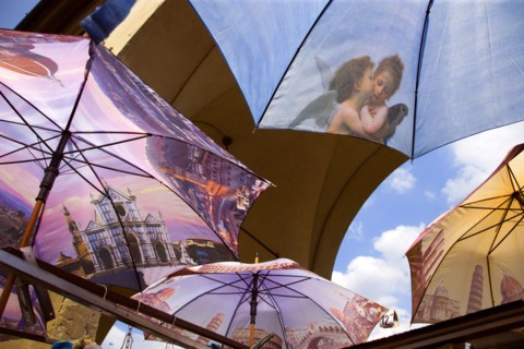 ITALY, Tuscany, Florence, Brightly coloured umbrellas for sale on the Ponte Vecchio with images of