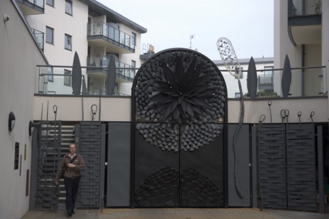 ENGLAND, East Sussex, Brighton, Ornate gates to new housing apartment development in West street.