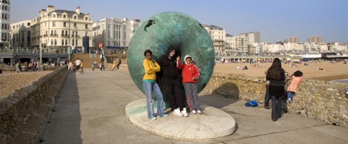 ENGLAND, East Sussex, Brighton, Tourists posing for photographs next to sculture on the seafront.