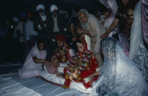 ENGLAND, Religion, Sikhism, Bride and groom receiving gifts of money from guests during wedding